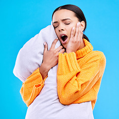 Image showing Tired woman, pillow and yawn in studio with exhausted face, and ready to sleep by blue background. Girl, model and open mouth for sleeping, rest or nap for self care, mental health and peace of mind