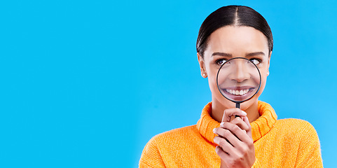 Image showing Happy, smile and woman with magnifying glass in studio for zoom on her mouth for dental health. Happiness, excited and female model from Brazil with magnifier isolated by blue background with mockup.