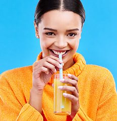 Image showing Happy woman, portrait and straw for drinking orange juice in studio, blue background and smile. Female model, glass and sip of fruit cocktail for nutrition, vitamin c diet and detox vegan smoothie