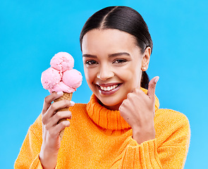 Image showing Woman, studio portrait and ice cream with thumbs up, smile and happiness by blue background. Girl, model and sweet dessert with hand sign, happy and excited for food, gelato and eating by backdrop