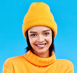 Image showing Portrait of happy woman in winter fashion with beanie, jersey and isolated on blue background. Style, happiness and gen z girl in studio backdrop with smile on face and warm clothing for cold weather