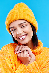 Image showing Happiness, excited portrait and woman with mockup in studio ready for cold weather with winter hat. Isolated, blue background and mock up with a happy young and gen z person with a smile and beanie