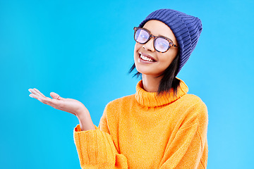 Image showing Woman palm, smile and portrait in a studio with promotion and announcement. Excited, isolated and blue background with mockup of a gen z girl and cool young female show marketing with happiness