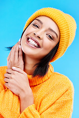 Image showing Happiness portrait, excited and woman with youth in studio ready for cold weather with winter hat. Isolated, blue background and positivity with a young and gen z person with a smile, beanie and joy