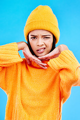 Image showing Portrait of woman in winter fashion with confused face, beanie and doubt isolated on blue background. Style, expression and attitude, gen z girl on studio backdrop with warm clothing for cold weather