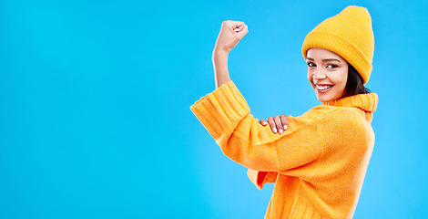 Image showing Strong, mockup and a portrait of a woman with muscle isolated on a blue background in a studio. Smile, style and a girl showing fashion for empowerment and confidence on a backdrop with space