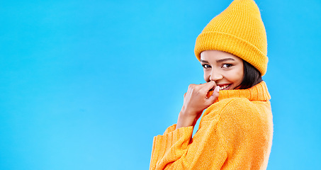 Image showing Happiness, excited and woman portrait with mockup in studio ready for cold weather with winter hat. Isolated, blue background and mock up with a happy young and gen z person with a smile and joy