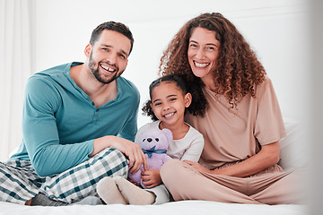 Image showing Portrait, love and family in bed, smile and bonding for quality time, comfortable and relax. Face, happy parents and mother with father, female child and daughter in bedroom, interracial or happiness