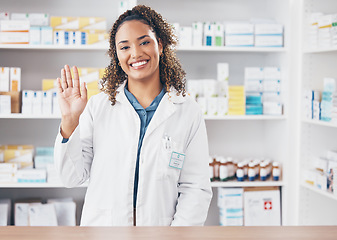 Image showing Wave, pharmacist or portrait of woman in pharmacy with smile in customer services or wellness clinic. Healthcare help desk, welcome or happy doctor with hello greeting by medication on drugstore