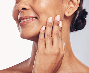 Image showing Hand, mouth and facial with a mature woman in studio for skincare, anti aging treatment or cosmetics. Beauty, skin and wellness with a senior female moisturizing her face for hydration closeup