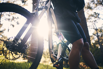 Image showing Closeup man, bike and flare in nature, park and sports adventure of freedom, athlete and sunshine. Cycling, bicycle and cyclist on a break outdoor for fitness, cardio exercise and training for action