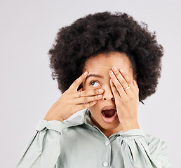 Image showing Shock, scared and a black woman looking through hands isolated on a white background in a studio. Wow, scary and an African girl covering eyes with a hand for a horror, bad surprise or frightened