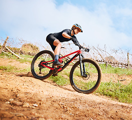 Image showing Bicycle, hill ride and woman outdoor on a bike with speed for sports race on a gravel road. Fitness, exercise and fast athlete doing sport training in nature on a park trail for cardio and workout