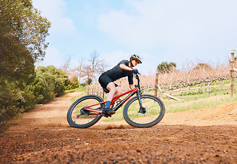 Image showing Bicycle, ride outdoor and fitness woman on a bike with speed for sports race on a nature dirt road. Exercise, fast and athlete doing sport training on countryside trail for cardio and cycling workout