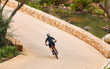 Image showing Bike, cycling and a sports person on a path outdoor for cardio or endurance exercise and health. Bicycle, fitness and workout with an athlete or cyclist training alone outside in the countryside