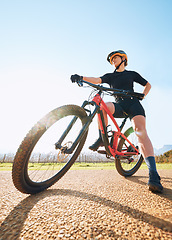 Image showing Bicycle break, ride and woman on a bike from below for sports race on a gravel road. Fitness, exercise and athlete doing sport training in nature or countryside for cardio rest and healthy workout