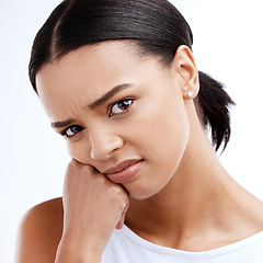 Image showing Portrait, unhappy and frustrated with a woman in studio isolated on a white background looking moody. Face, frown and negative with a young woman looking confused, angry or bored while alone indoor