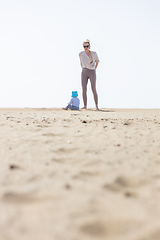 Image showing Mother playing his infant baby boy son on sandy beach enjoying summer vacationson on Lanzarote island, Spain. Family travel and vacations concept.