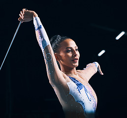 Image showing Ribbon gymnastics, woman and performance of dancer in talent show, training and competition in dark arena. Female athlete, rhythmic movement and action of creative event, sports concert and dancing