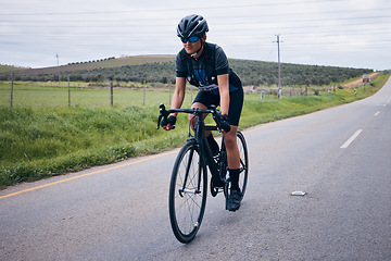 Image showing Fitness, cycling and man on a bicycle in nature training for a race, marathon or competition. Sports, workout and male athlete cyclist riding a bike for cardio exercise on a road in the mountain.