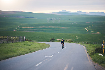 Image showing Fitness, nature and cyclist cycling on a mountain while training for a race, competition or marathon. Sports, health and athlete doing a cardio exercise or workout with bicycle in the road on a hill.