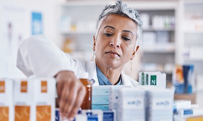 Image showing Pharmacist woman, shelf and packing box for stock, inventory and organized store for healthcare. Pharmacy, senior business owner and medicine with focus for pills, customer experience and wellness