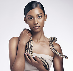 Image showing Beauty, portrait and woman in studio with snake on neck for art aesthetic with exotic zoo animal on white background. Face, skin and creative style, asian fashion model holding dangerous pet python