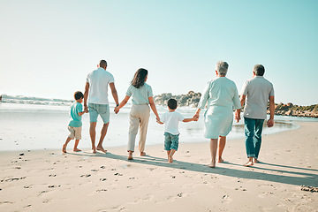 Image showing Big family, holding hands and walking outdoor on beach with children, grandparents and parents . Men, women and boy kids walk by sea for summer travel vacation or holiday with love, care and support