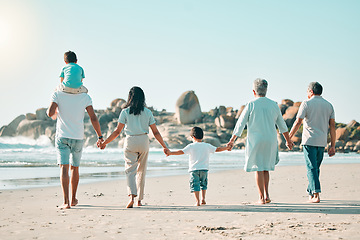 Image showing Holding hands, beach and rear view of big family walking at the sea, fun and travel on blue sky background. Behind, love and children with parents and grandparents on an ocean walk traveling in Miami