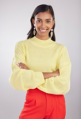 Image showing Fashion, portrait and female with crossed arms in a studio with a stylish, trendy and classy outfit. Smile, happy and young Indian woman model with style and confidence isolated by a gray background.