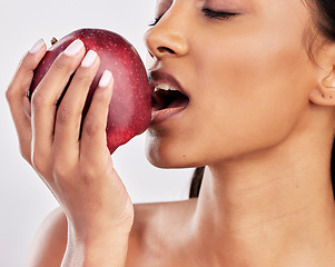 Image showing Bite, apple or healthy Indian woman with skincare beauty or wellness in studio on white background. Food nutrition, eyes closed or face of girl model eating red fruits to promote vitamin c or diet