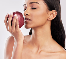 Image showing Eating, apple or healthy Indian woman with skincare beauty or wellness in studio on white background. Food nutrition, eyes closed or face of girl model with red fruits to promote vitamin c or diet