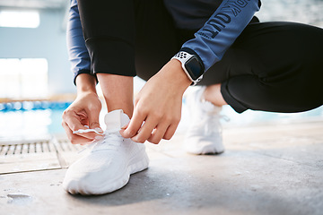 Image showing Tie shoes, hands and fitness at swimming pool to start workout, exercise or training. Sports, athlete and woman tying sneakers to get ready for swim, practice or exercising for health and wellness.