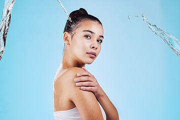 Image showing Water splash, skincare and portrait of woman with health, wellness and cleaning isolated on blue studio background. Shower, mockup and cosmetic beauty glow, model in skin care treatment or routine.