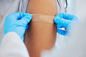 Image showing Person, arm closeup and covid with a plaster and hands for healthcare and medical injection. Patient and doctor at a clinic or hospital for vaccine with a bandage for virus, health and wellness shot