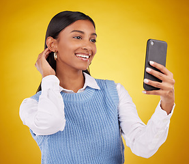 Image showing Happy, pose and selfie with woman in studio for social media, technology and internet post. App, online and picture with female on yellow background for happiness, connection and photography