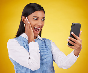 Image showing Phone surprise, online news and happy woman shocked over mobile notification, app promotion or wow discount. Reading OMG info, cellphone announcement and excited studio female on yellow background