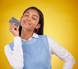 Image showing Credit card, smile and Indian woman on yellow background for bank, investment and payment in studio. Banking mockup, finance and happy girl with plastic for budget, commerce and promotion purchase