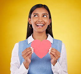 Image showing Smile, paper and heart with woman in studio for love, support and romance. Valentines day, kindness and date with female and holding symbol on yellow background for health, happiness and hope mockup