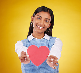 Image showing Giving, paper and heart with portrait of woman in studio for love, support and romance. Valentines day, kindness and date with female and symbol on yellow background for health, happiness and hope