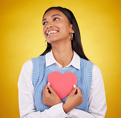 Image showing Love, paper and heart with woman in studio for happy, support and romance. Valentines day, kindness and date with female and holding symbol on yellow background for health, happiness and hope mockup