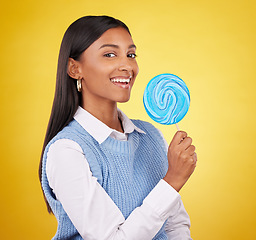 Image showing Smile, lollipop and candy with portrait of woman in studio for sweets, snack and food. Treats, dessert and sugar confectionery with female isolated on yellow background for diet, eating and happy