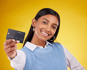 Image showing Credit card, portrait and Indian woman on yellow background for bank, investment and payment in studio. Banking mockup, finance and happy girl with plastic for budget, commerce and promotion purchase