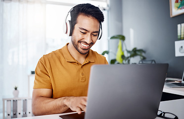 Image showing Man is working from home, laptop and headphones while listening to music, happy and busy at desk. Male copywriter typing, freelance and blogger with remote work, technology and online audio streaming