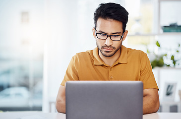 Image showing Serious, work and an Asian man with a laptop in a home office for communication, email and internet. Business, research and an entrepreneur or freelance worker typing a proposal on a computer