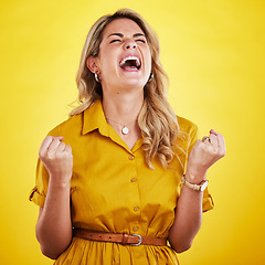 Image showing Woman, fist celebration and shout in studio for winning, goals or success with happiness by yellow background. Girl, happy and winner with crazy screaming for bonus, profit or prize from competition