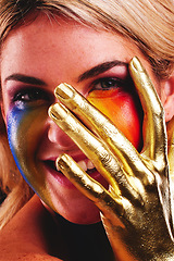 Image showing Gold hand, woman and beauty portrait with color paint cosmetics on skin and face in studio. Female model person with a happy smile for art deco, fantasy and creative makeup with metallic shine