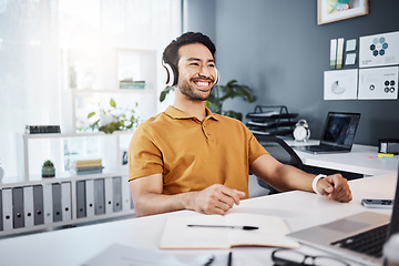 Image showing Business man, smile and thinking with headphones while listening to music, audio or podcast in office. Asian male entrepreneur at desk while excited for idea, plan or goals at a modern workplace