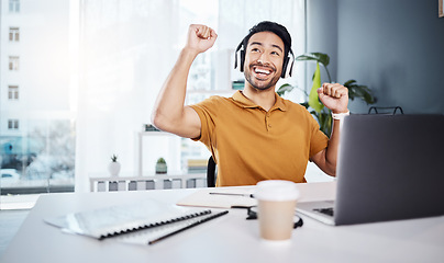 Image showing Laptop, headphones and business man celebrate success while listening to music, audio or video call. Excited asian male entrepreneur at desk with smile and hands for achievement, win or goals