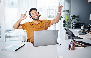 Image showing Business man, dancing and laptop with headphones to listen to music or celebrate success. Happy asian male entrepreneur at desk with a smile and hands for achievement, victory dance or goals